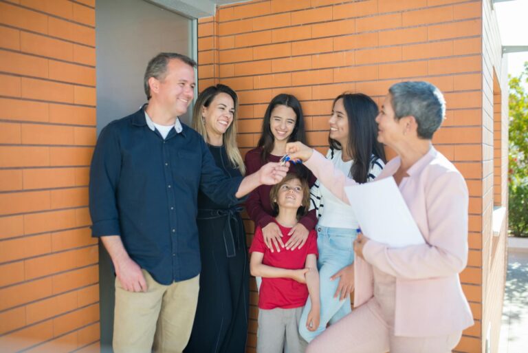 Family joyfully receiving keys to their new home outdoors, symbolizing real estate success.