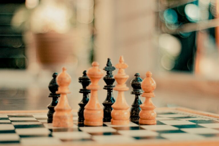 Chess pieces on a board with a bokeh background, emphasizing strategy and focus.