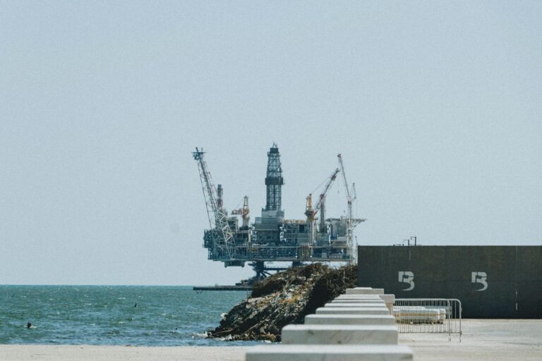 Distant view of an offshore oil rig with cranes on a sunny day.