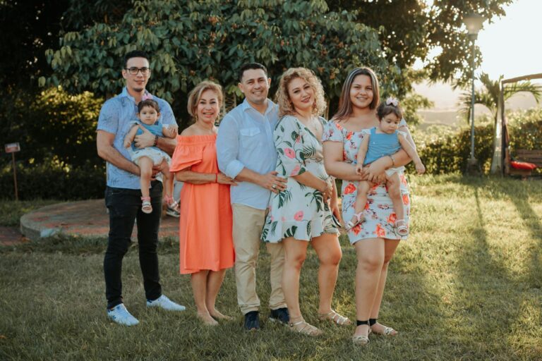A joyful family posing together outdoors at sunset in a park.