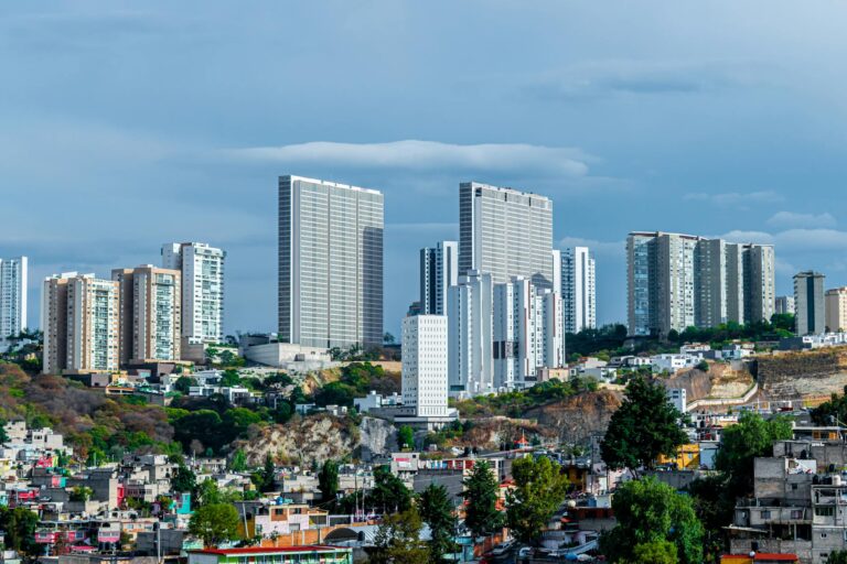 Panoramic view of a modern cityscape featuring high-rise buildings under a blue sky.